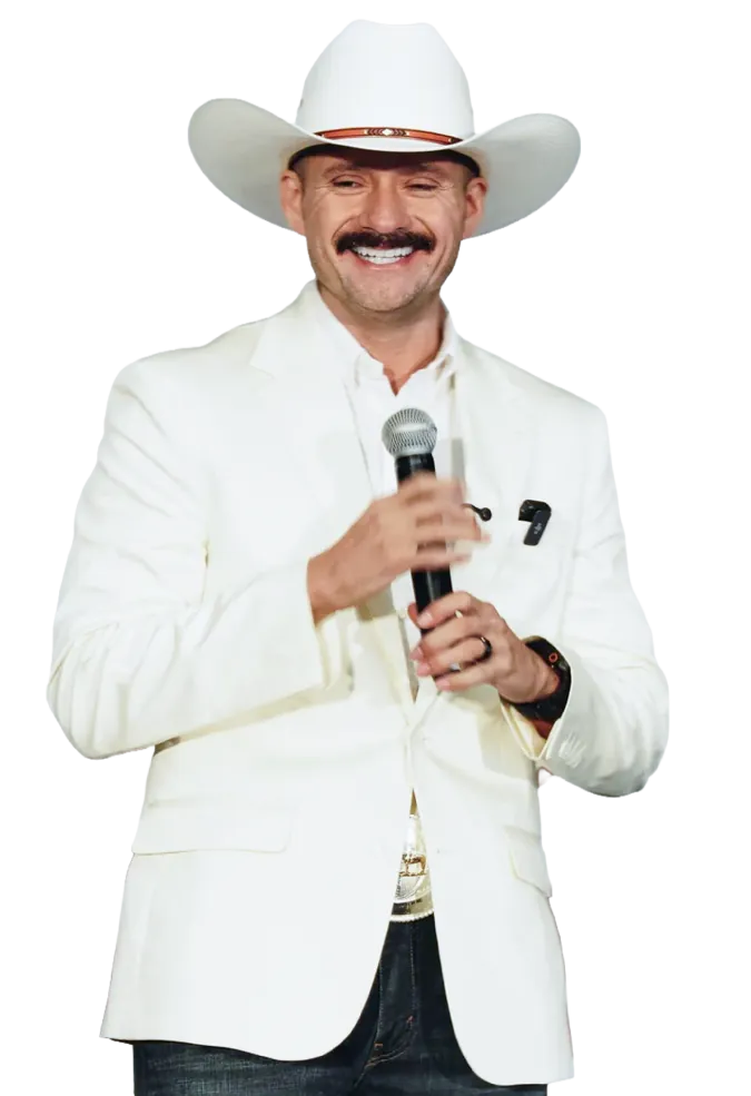 Marcos Ramírez sonriente, con micrófono y traje blanco
